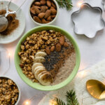 Smothiebowl med banan, mandel och granola uppdukad på juligt bord