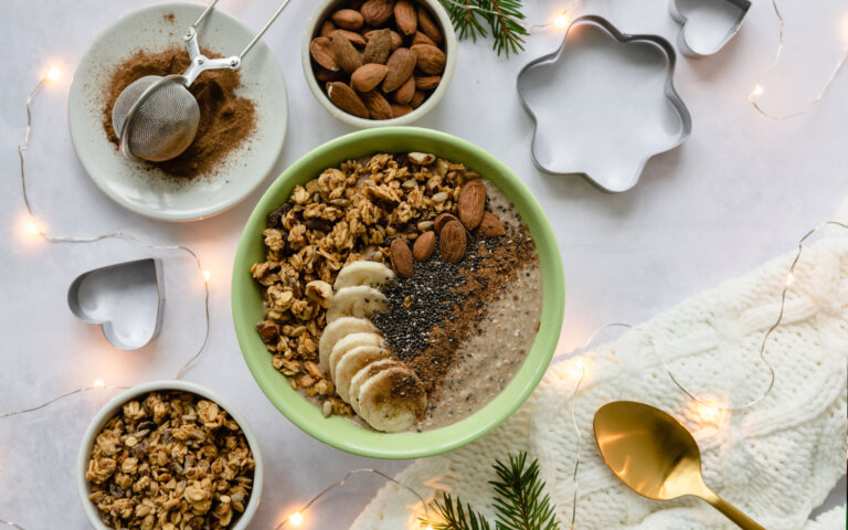 Smothiebowl med banan, mandel och granola uppdukad på juligt bord