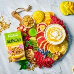 Pauluns breakfastboard med färska frukter och bär och skålar med yoghurt och granola
