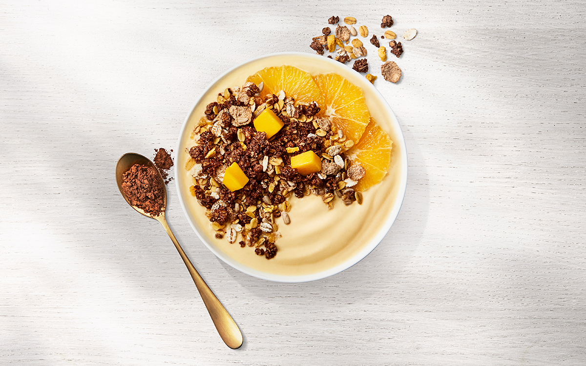 Gul mango smoothiebowl med kakao och apelsinmüsli