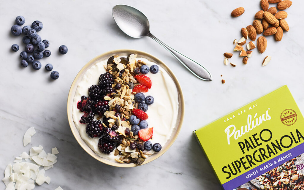 En skål med yoghurt toppad med Paulúns paleo supergranola