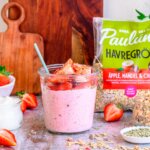 Glasburk med overnight oats med kvarg, mjölk, jordgubbar, förpackning med Pauluns havregröt med äppke, mandel och chia.